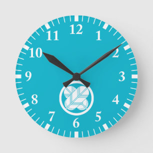 Intersecting hawk feathers with foot in circle round clock