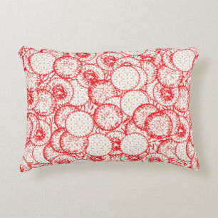 Intricate textile design featuring red, gold, and decorative cushion