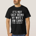 It's Not Easy Being My Wife's Arm Candy | Funny T-Shirt<br><div class="desc">Embrace the challenge with humour! This hilarious T-shirt proudly declares, 'It's Not Easy Being My Wife's Arm Candy, ' showcasing your wit and charm. Perfect for husbands who know how to navigate the spotlight with a smile. Crafted with comfort and a dash of playfulness, this tee is a must-have for...</div>