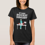 It's Not Rocket Surgery T-Shirt<br><div class="desc">It’s Not Rocket Surgery. This funny quote accessory is a combination of the sayings “It’s not rocket science” and “It’s not brain surgery”, an example of a malaphor. Great gift for a doctor, surgeon or a med student completing medical school! If you love funny sayings, have a sense of humour...</div>