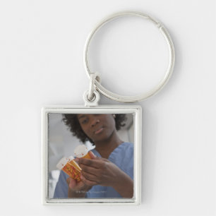 Jamaican female nurse checking pill bottles key ring