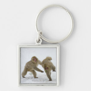 Japanese Snow Monkey cubs playing on snow Key Ring