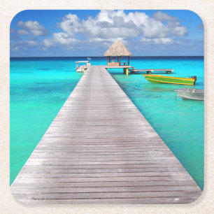 Jetty with boats in a tropical lagoon square paper coaster