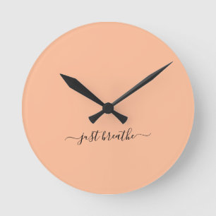 Just breathe orange elegant script yoga  round clock