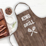 King of the Grill Funny Barn Wood Grilling Apron<br><div class="desc">The perfect apron for the guy who reigns as the supreme monarch of his grill. Two crossed spatulas appear silhouetted in white under the words "King of the Grill" in white on a brown barn wood pattern background. Makes an ideal birthday or Father's Day gift.</div>
