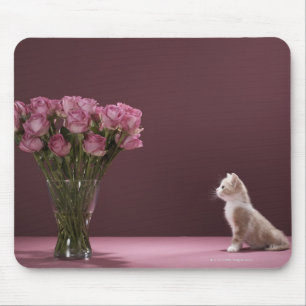 Kitten looking at vase of roses mouse pad