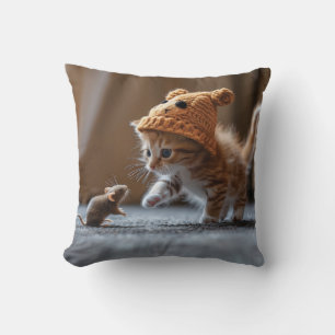 Kitten playing with a small mouse cushion