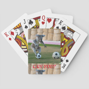 Koala on top of a soccer ball playing cards