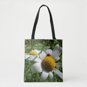 Ladybug on daisy in nature. tote bag