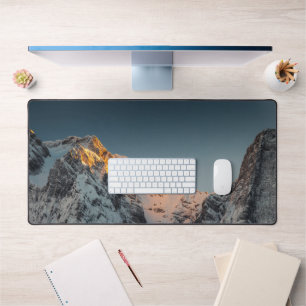 Last light before sunset on mountains desk mat
