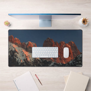 Last light of sun on mountains desk mat