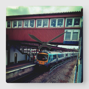 Light blue train , under the bridge square wall clock