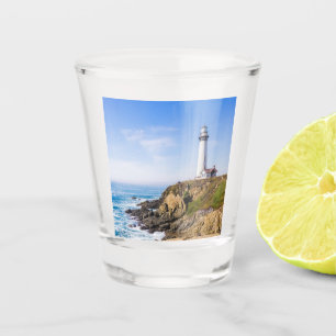 Lighthouse on hill blue sky white house ocean shot glass