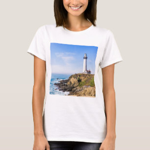 Lighthouse on hill blue sky white house ocean T-Shirt