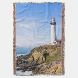 Lighthouse on hill blue sky white house ocean throw blanket