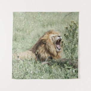 LION LYING ON GREEN GRASS DURING DAYTIME TAPESTRY