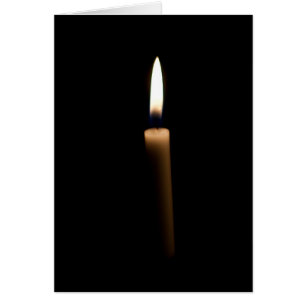 Lit candle in the dark