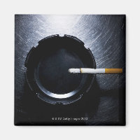 Lit Cigarette and Ashtray on Stainless Steel
