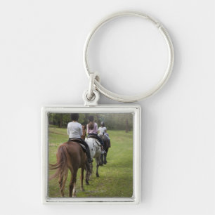 Little girls riding horses key ring