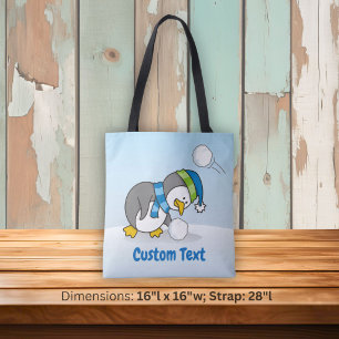 Little penguin getting a snow ball tote bag