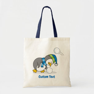 Little penguin getting a snow ball tote bag