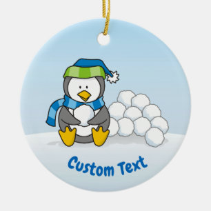 Little penguin sitting with snowballs ceramic ornament
