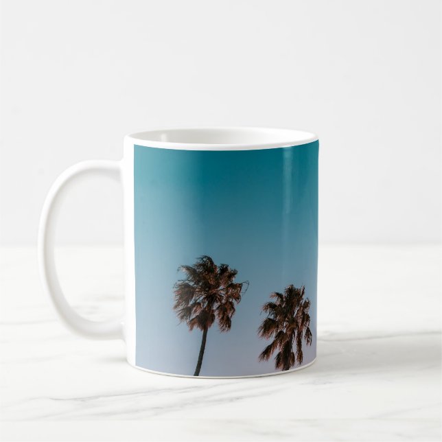 Low-angle photograph of three palm trees under blu coffee mug (Left)