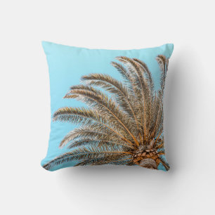 Low-angle photography of a green palm tree under a cushion
