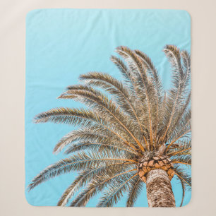 Low-angle photography of a green palm tree under a sherpa blanket