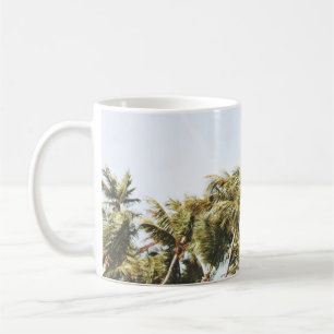 LOW-ANGLE PHOTOGRAPHY OF GREEN COCONUT TREES UNDER COFFEE MUG