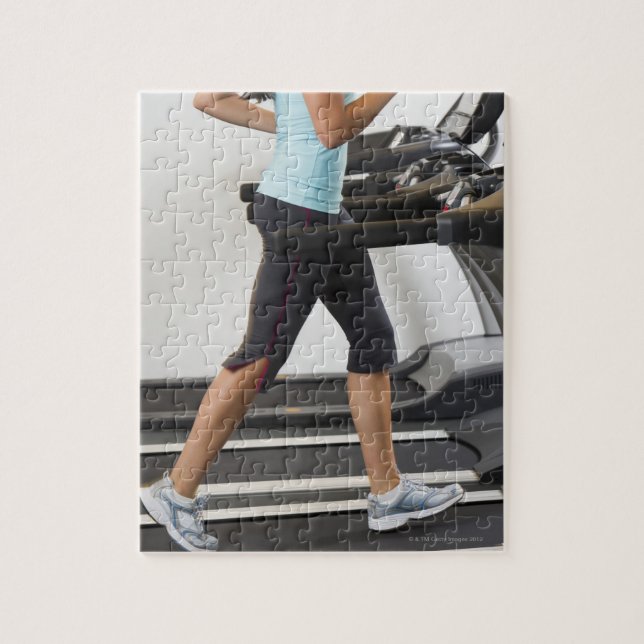 Low section of woman walking on treadmill jigsaw puzzle (Vertical)