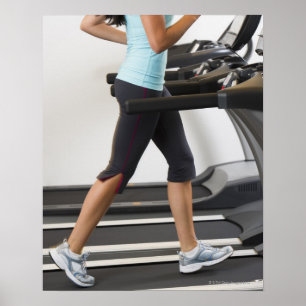 Low section of woman walking on treadmill poster