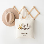 Lucky in Love Horseshoe Wedding Favour Tote Bag<br><div class="desc">Design features two golden horseshoes and “Lucky in Love" in warm autumn brown watercolor. Great wedding favour or welcome bag for out of town guests. Coordinating accessories available in our shop!</div>