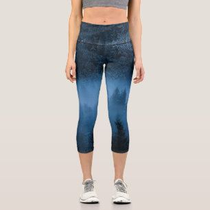 Magical fog over snowy spruce forest capri leggings