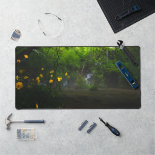 Magical forest with yellow flowers and waterfall desk mat