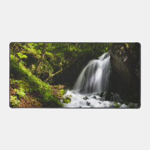 Magical waterfall in enchanting green forest desk mat