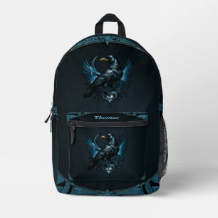 Majestic black raven sitting on an ornate printed backpack
