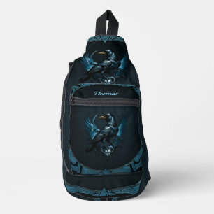 Majestic black raven sitting on an ornate sling bag