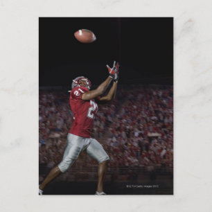 Male football player catching football postcard