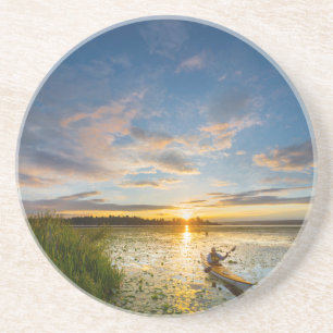 Male kayaker paddling sea kayak on still water coaster