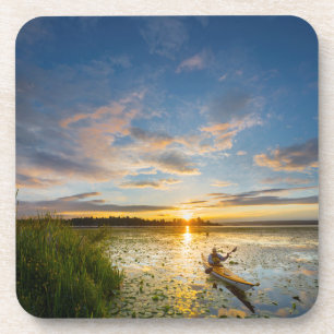 Male kayaker paddling sea kayak on still water coaster