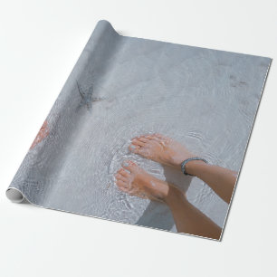 Man and woman on seashore nearby starfish wrapping paper