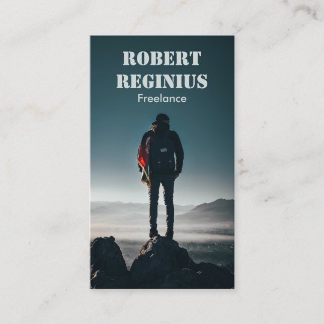 man carrying backpack standing on rock formation business card (Front)