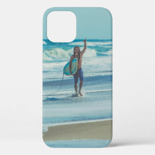 Man carrying surfboard at beach iPhone 12 case