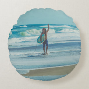 Man carrying surfboard at beach round cushion
