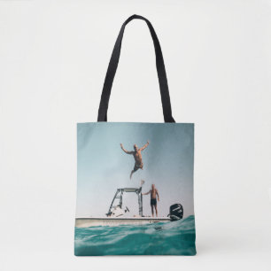 Man diving on pool tote bag