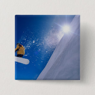 Man flying through the air on a snowboard with 15 cm square badge