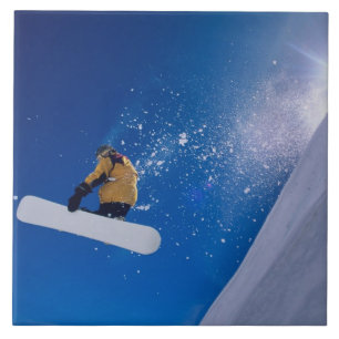 Man flying through the air on a snowboard with ceramic tile
