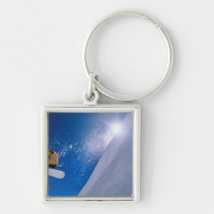 Man flying through the air on a snowboard with key ring