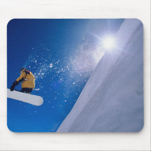 Man flying through the air on a snowboard with mouse pad